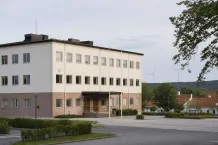 Svenskt kommunhus och vindkraftverk i ett öppet nordiskt landskap