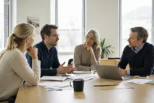 Personer runt ett bord i ett mötesrum i diskussion om branschens spelregler