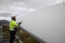 Tekniker som inspekterar ett stort vitt rotorblad på nära håll