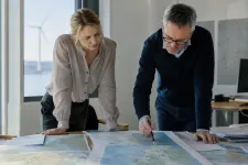 Tjänstemän som granskar kartor och handlingar utbredda på ett bord